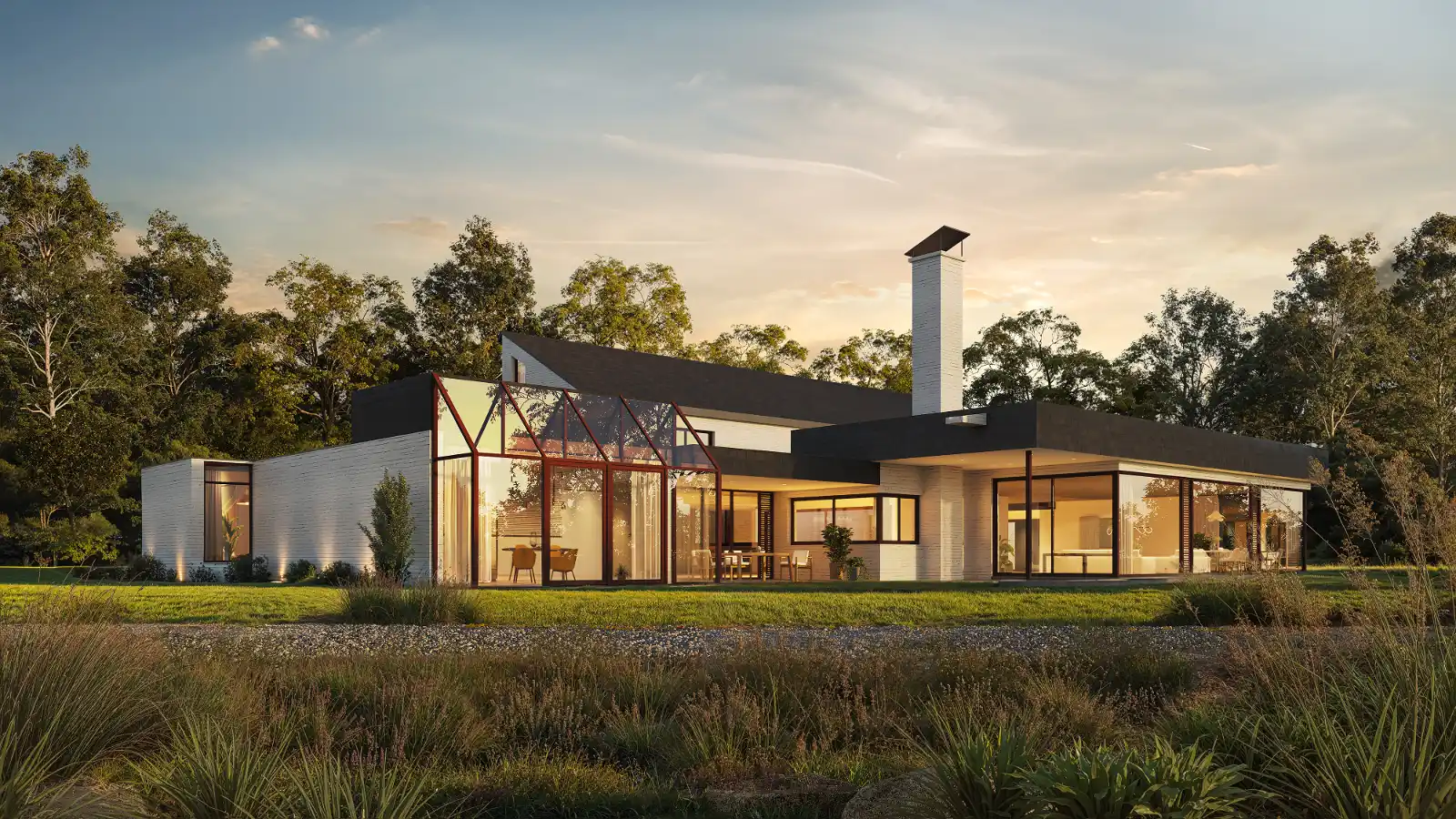 High-quality 3D architectural exterior visualization of a sprawling modern white brick house at dusk. The expansive rear view highlights a striking glass conservatory extension, a tall white chimney, and flat dark roof sections. Large floor-to-ceiling windows radiate warm interior lighting, contrasting beautifully with the twilight sky, mature surrounding trees, and natural wild grasses in the foreground.